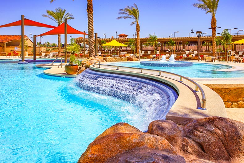 View of palm trees around the outdoor pool and patio at Sun City Festival in Buckeye, Arizona