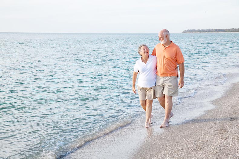 An active adult couple walking down the beach