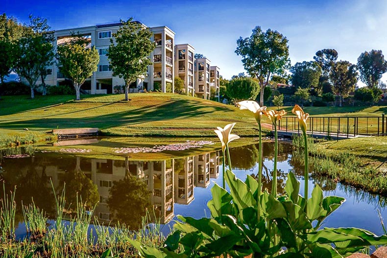 View across a picturesque pond of condo buildings at Laguna Woods Village in Laguna Woods, California