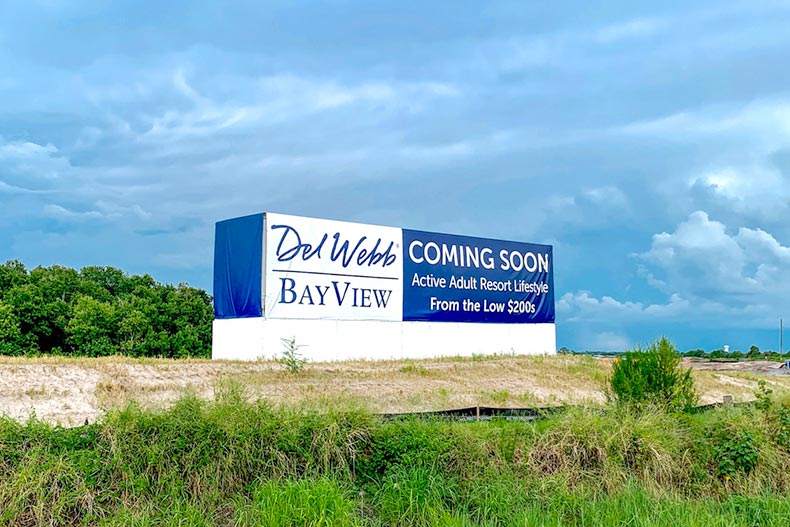 Greenery surrounding the "Coming Soon" sign for Del Webb BayView in Palmetto, Florida