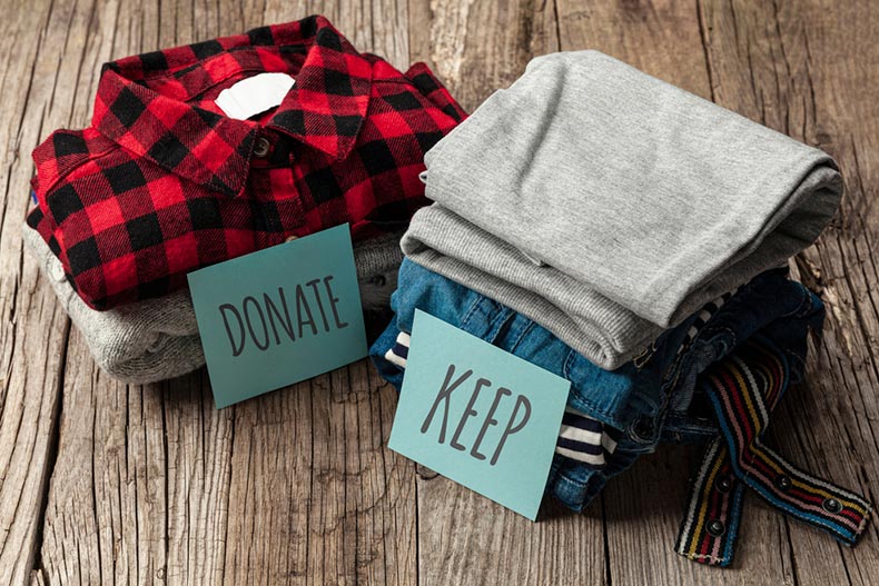 Two stacks of old clothes to "donate" or "keep"