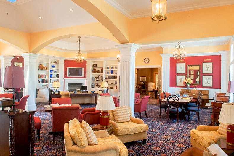 View of the tables and couches in the warm interior of the clubhouse at Falls Run in Fredericksburg, Virginia