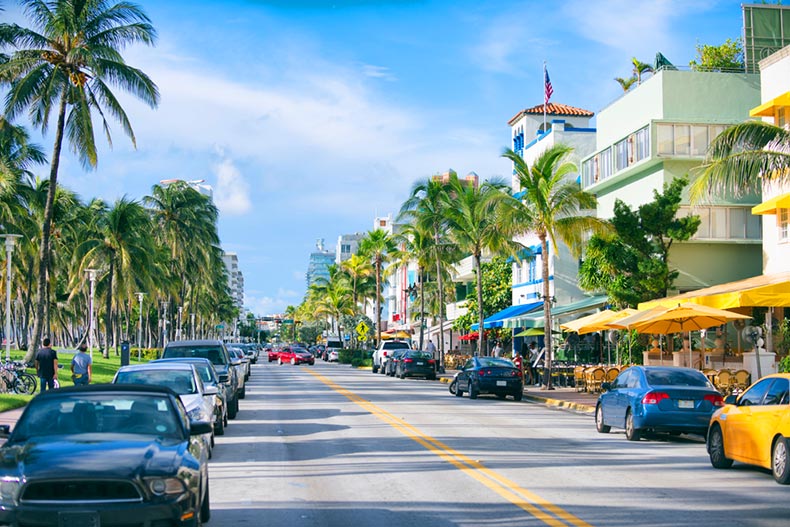Early morning view down Ocean Drive lined with palm trees and Art Deco hotels in Miami, Florida