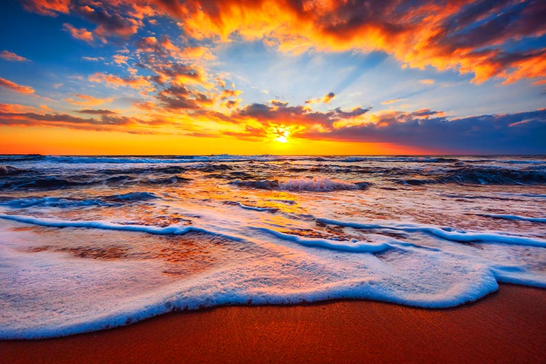 Sunrise over a beach with bright orange clouds in the sky located in Florida