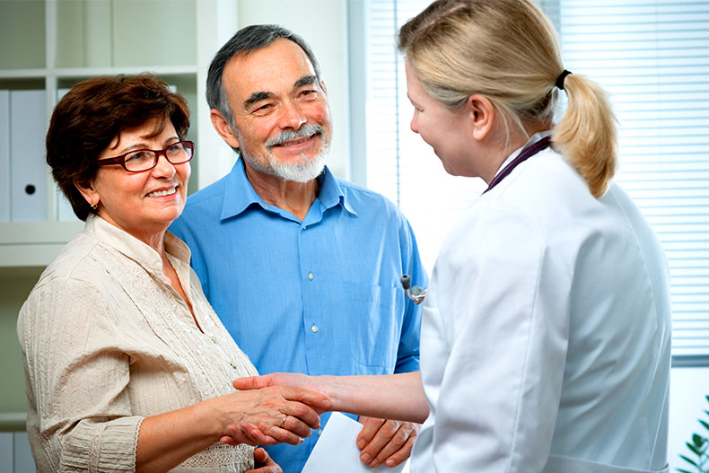 Retired couple shaking hands with a doctor.