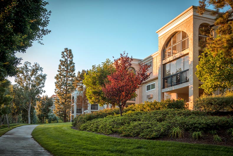 Exterior of a condo building in Laguna Woods Village, California taken from a sidewalk during autumn