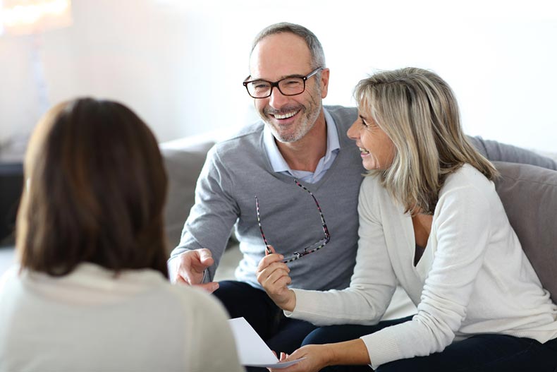 A senior couple meeting with their real estate agent to negotiate on a house