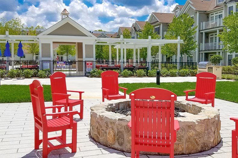 Wooden chairs surrounding the outdoor fire pit at Nobility Crest at Ocean in Ocean Township, New Jersey