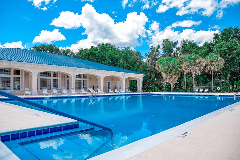 Lounge chairs on the patio beside the outdoor pool at Oak Run in Ocala, Florida