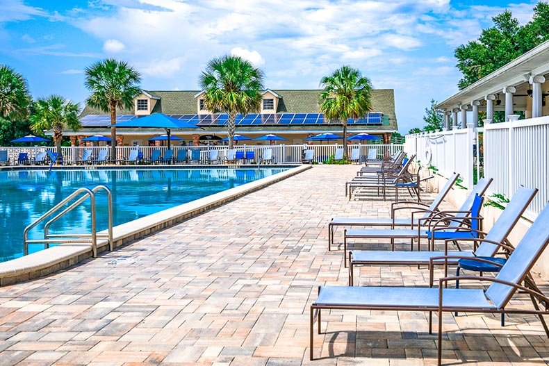 Lounge chairs on the patio beside an outdoor pool at On Top of the World in Ocala, Florida