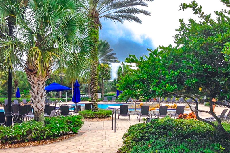 View of the outdoor patio with seating and a pool in the background at Pelican Preserve.