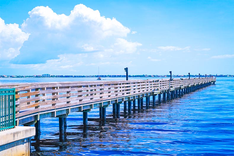 A pier over blue water and under blue skies in Port Charlotte, Florida