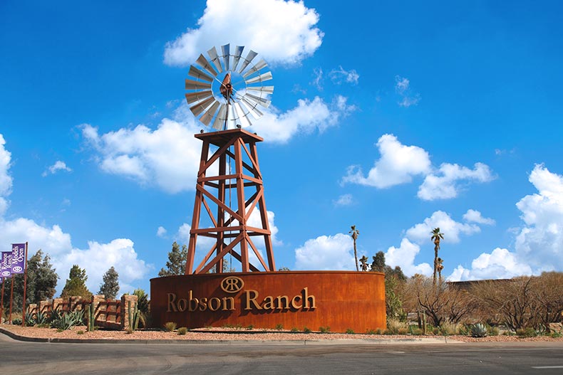 A wooden windmill behind the community sign for Robson Ranch - Arizona in Eloy, Arizona