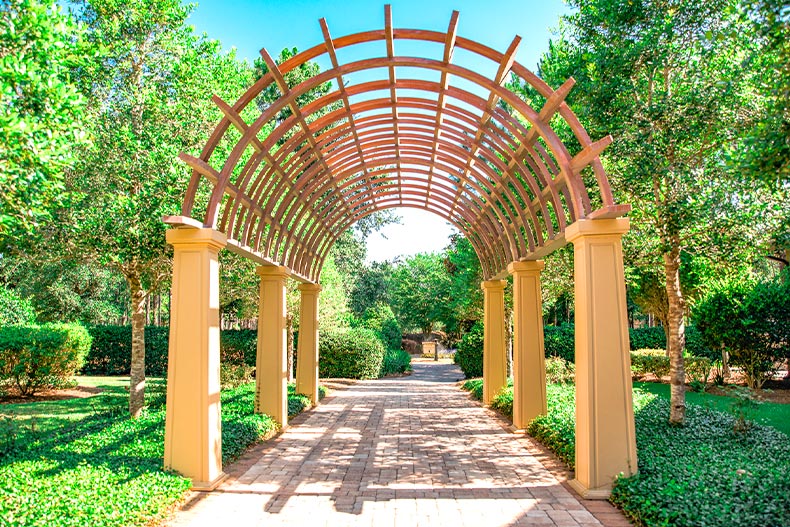 Photo of a brick pathway passing under a wood archway in Stone Creek of Ocala, Florida