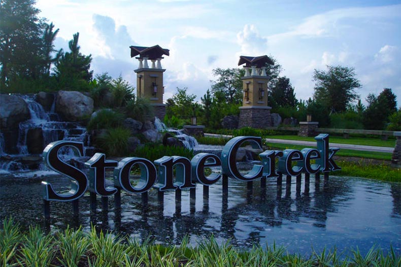 View of the community sign and entrance gate surrounded by well-manicured landscaping at Stone Creek in Ocala, Florida
