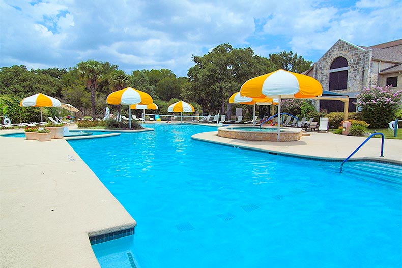 Pool with yellow and white umbrellas in Sun City Texas in Georgetown