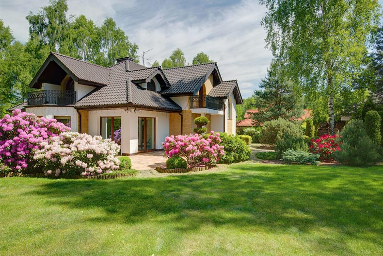 Flowers surrounding an elegant villa with a backyard