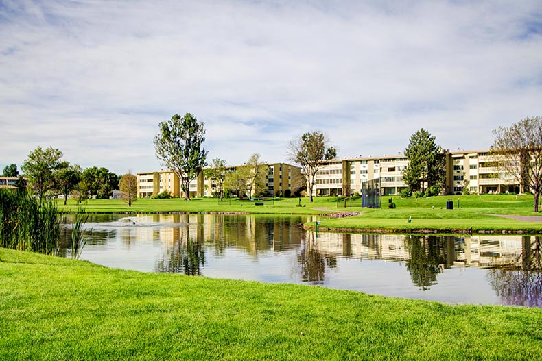 View across a pond of the condo building at Windsor Gardens in Denver, Colorado