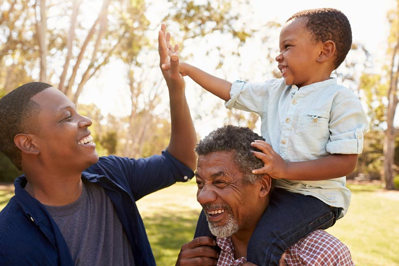 A grandfather with a father and son in a park in a 55+ community