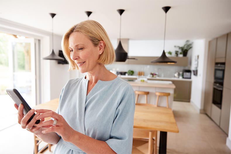 An active adult woman using an app to help her move into a new home