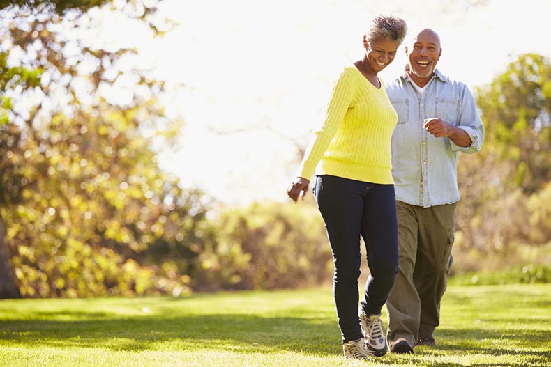 An active adult couple smiling while going for a walk on a sunny day