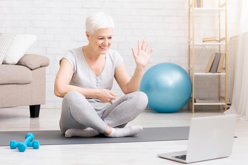 Sporty mature woman getting ready to follow a workout from her laptop