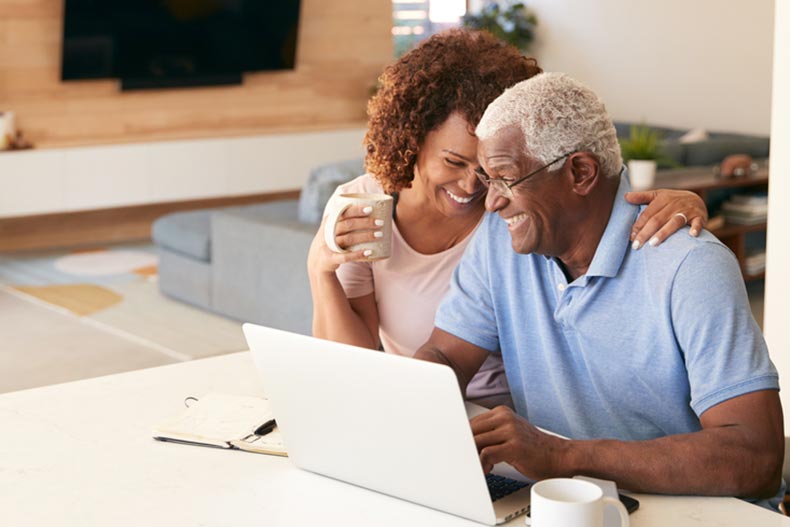 A senior couple using a laptop to check finances at home