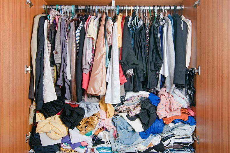 An older adult's closet that's stuffed full of clothing