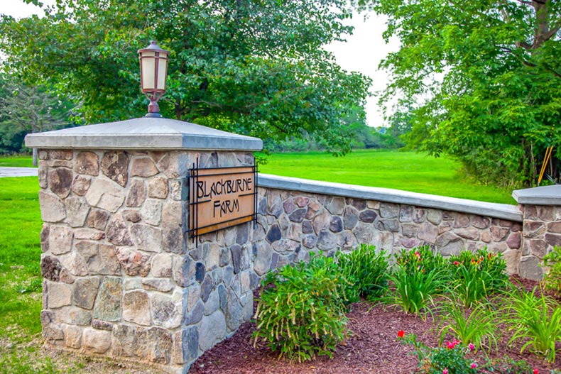 A stone wall with the community sign for Blackburne Farm Townhomes in Campbell Hall, New York