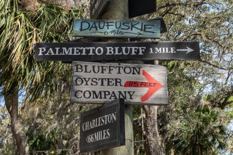 A directional sign in Bluffton, SC with arrows for May River, Charleston, Palmetto Bluff, Daufuskie, TYB, and the Bluffton Oyster Company