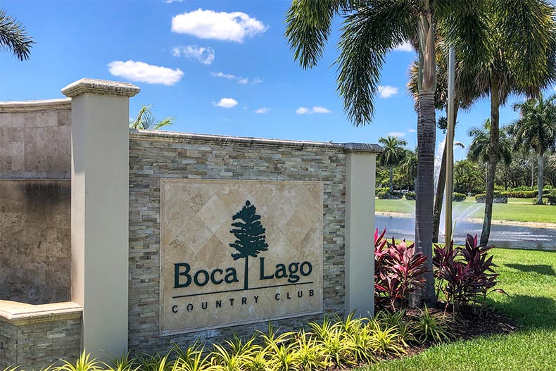 A palm tree beside the community sign for Boca Lago in Boca Raton, Florida
