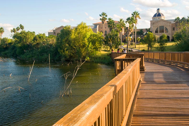 A boardwalk over a pond surrounded by trees in Brownsville, Texas