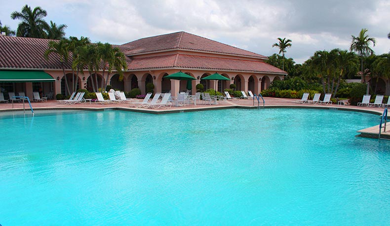 Exterior photo of the clubhouse and outdoor pool at The Cascades 55+ community in Boynton Beach, Florida