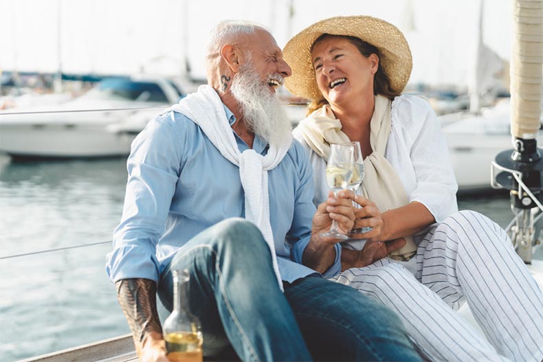 A senior couple toasting champagne on a sailboat to celebrate their retirement