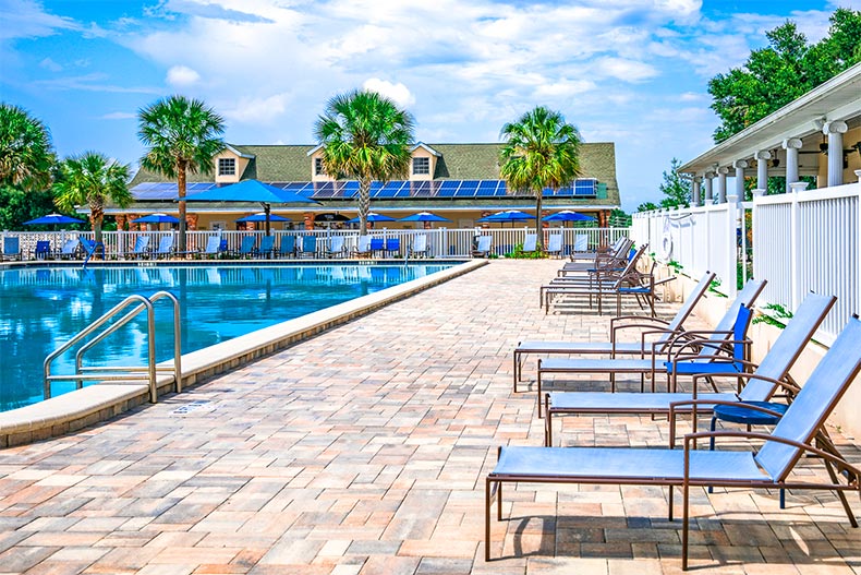 Lounge chairs on the patio beside an outdoor pool at On Top of the World in Ocala, Florida