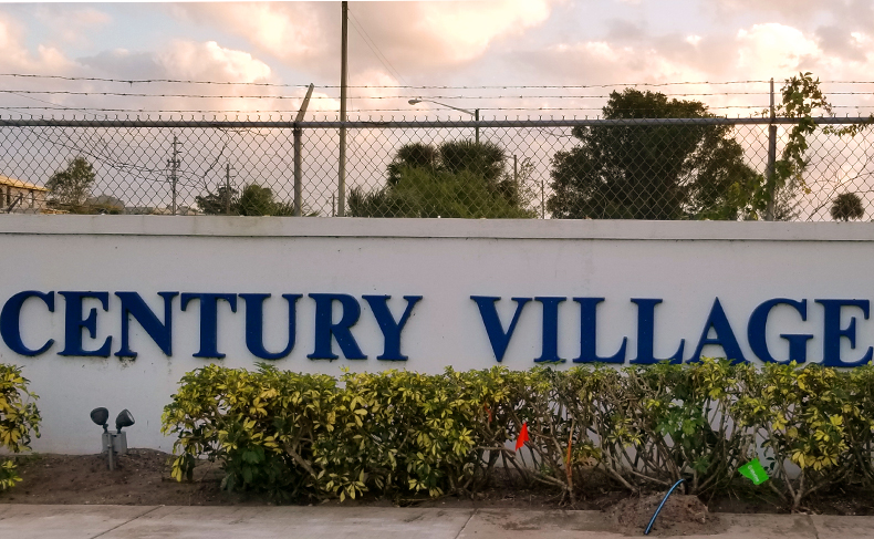 The community sing for Century Village at West Palm Beach with short bushes in front, located in West Palm Beach, Florida