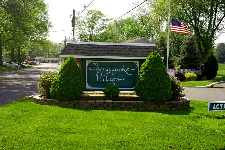 View of the Cheesequake Village community sign surrounded by small shrubs, located in Old Bridge, New Jersey