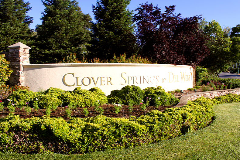 The community sign for Clover Springs surrounded by shrubbery located in Cloverdale, California