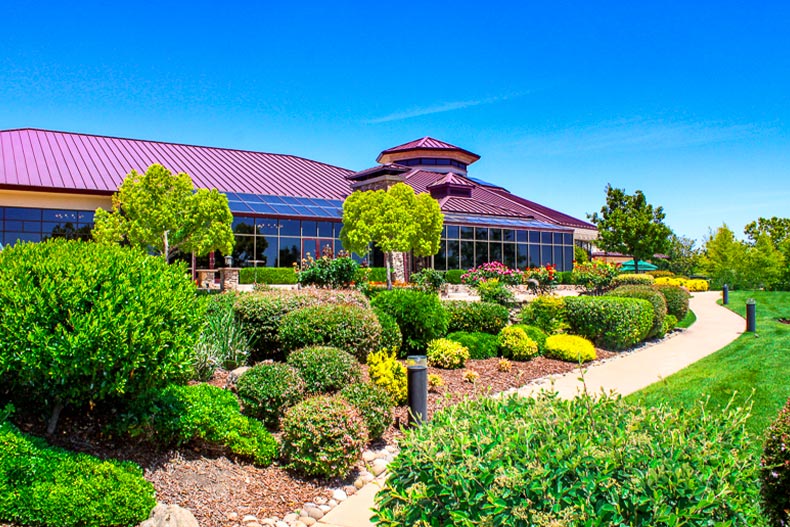 A bush garden and pathway in front of a clubhouse in Sun City Lincoln Hills, located in Lincoln, California