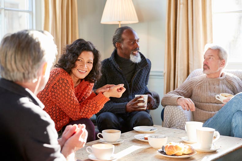 Older friends socializing in a living room in a detached condo in a 55+ community