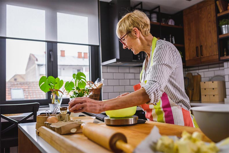Older women preparing ingredients in modern kitchen