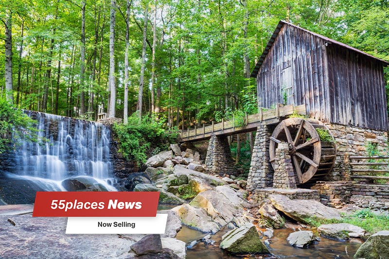 Historic mill and waterfall in Marietta, Georgia with 55places News banner and text reading "Now Selling".