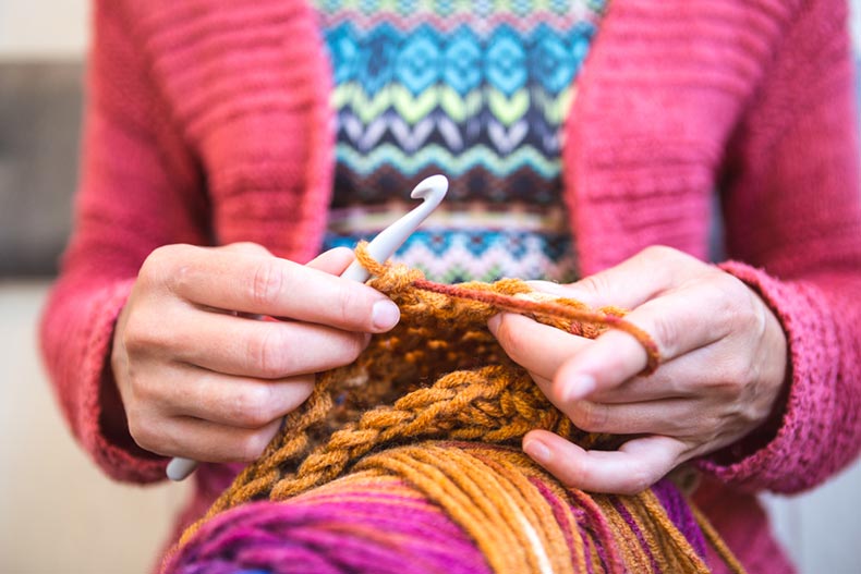 Closeup on the hands of an older woman crocheting
