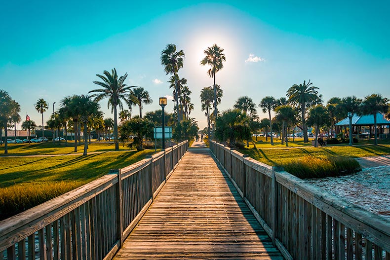 Photo of a fishing pier with palm trees surrounding it at sunset in Daytona Beach, Florida