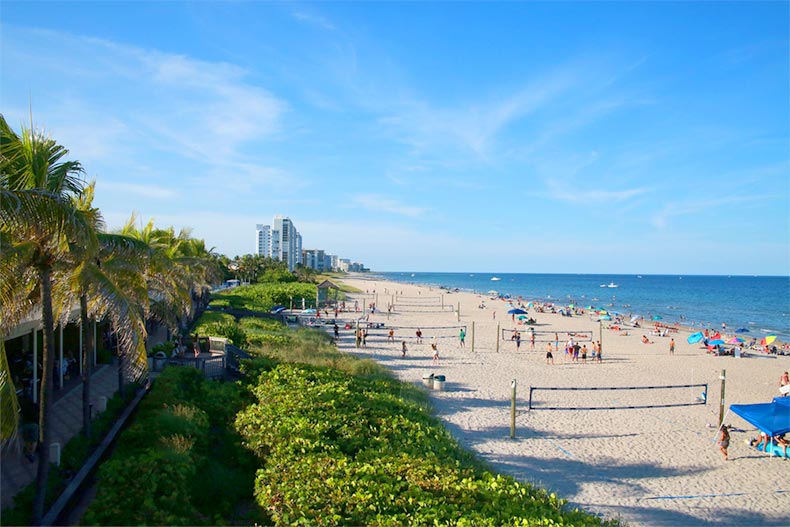 North side of Deerfield Beach in Florida with beachgoers sunbathing and enjoying water activities