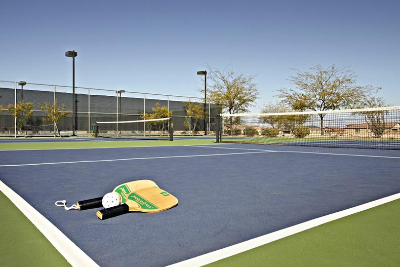 Paddles and a ball on the pickleball court at Del Webb at Rancho Del Lago in Vail, Arizona