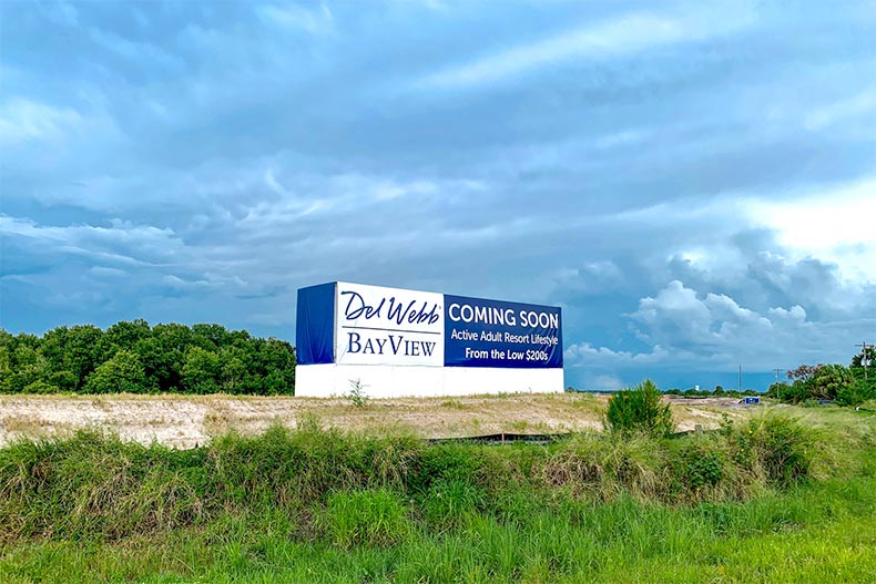 Greenery surrounding the "Coming Soon" sign for Del Webb BayView in Palmetto, Florida