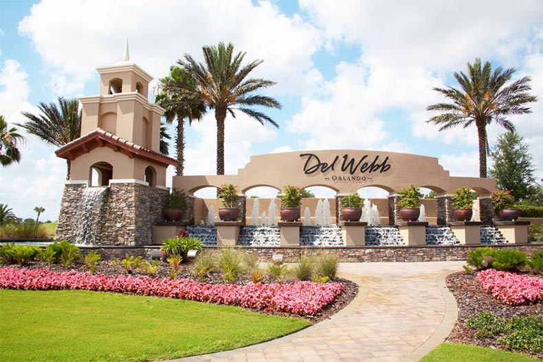 Palm trees surrounding the community sign and water feature at Del Webb Orlando in Davenport, Florida