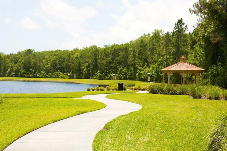 An outdoor walking path beside a pond at Del Webb Ponte Vedra in Ponte Vedra, Florida
