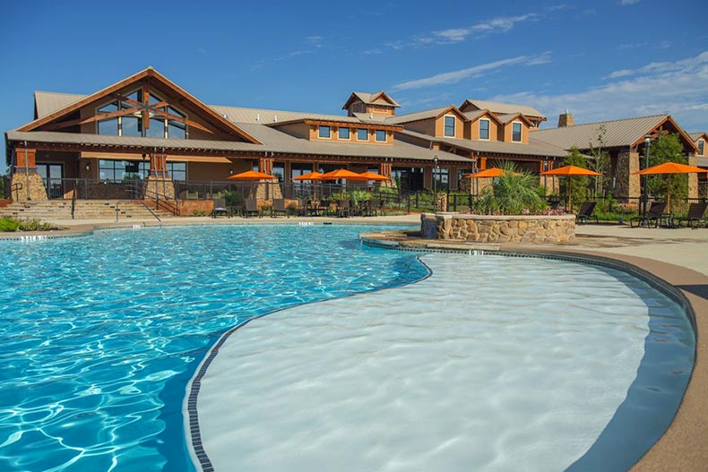 View of the clubhouse and outdoor pool at Del Webb Sweetgrass in Richmond, Texas